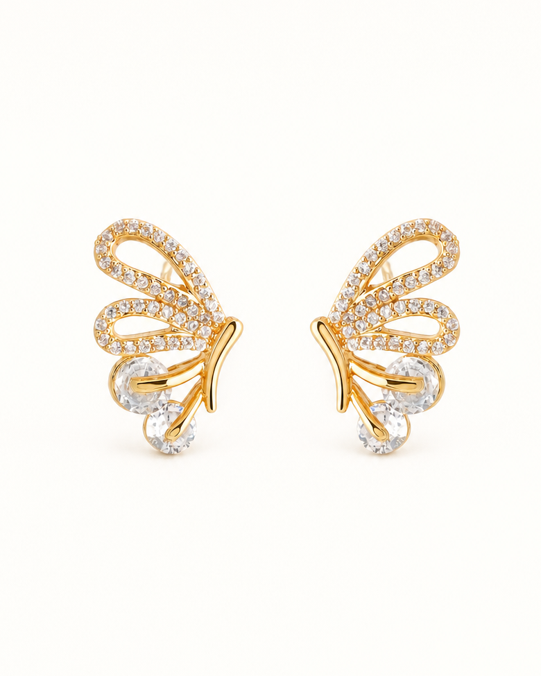 A pair of gold butterfly wing stud earrings embellished with small clear pavé stones and larger clear teardrop-shaped stones, set against a plain white background.